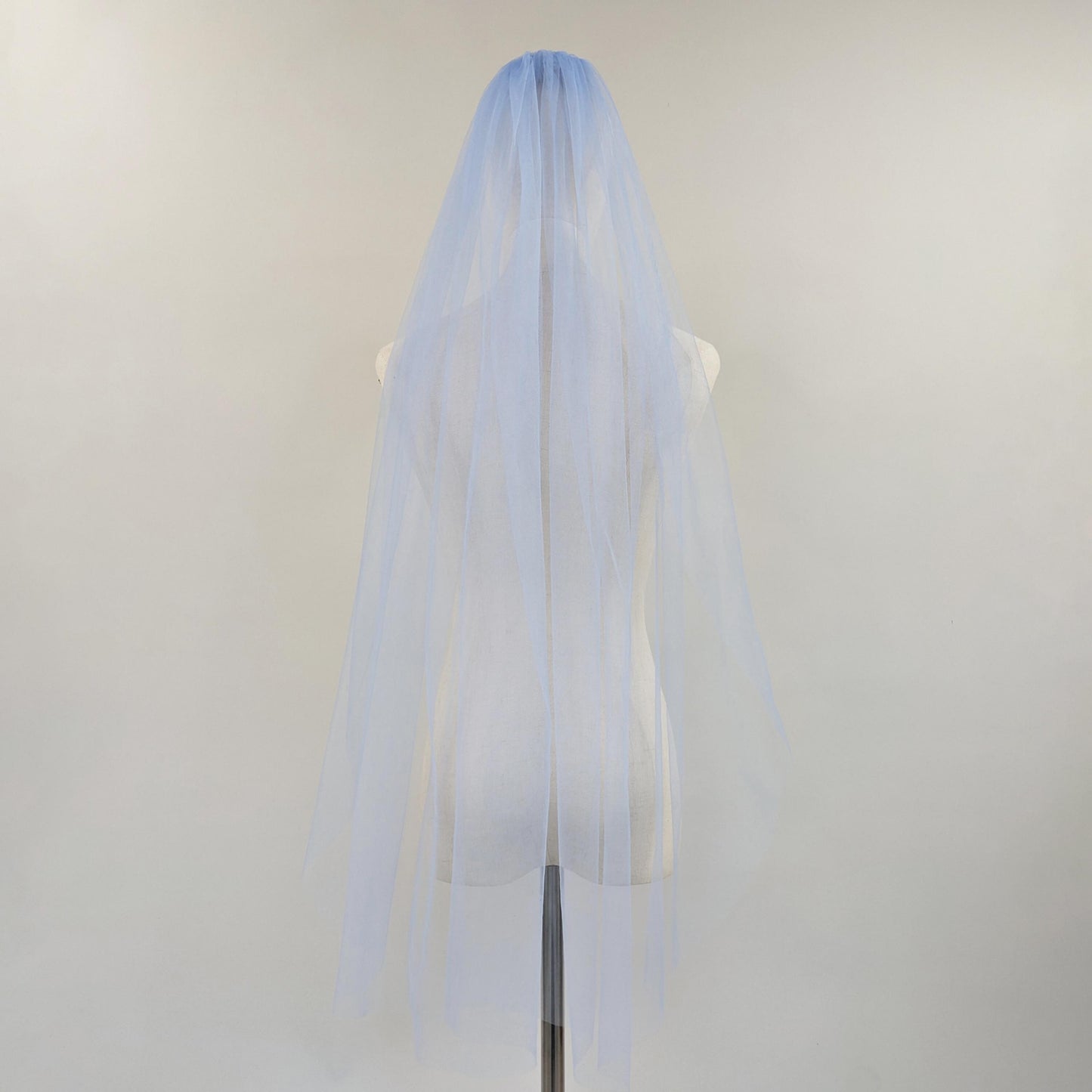 Light blue wedding veil on a mannequin head against a white background
