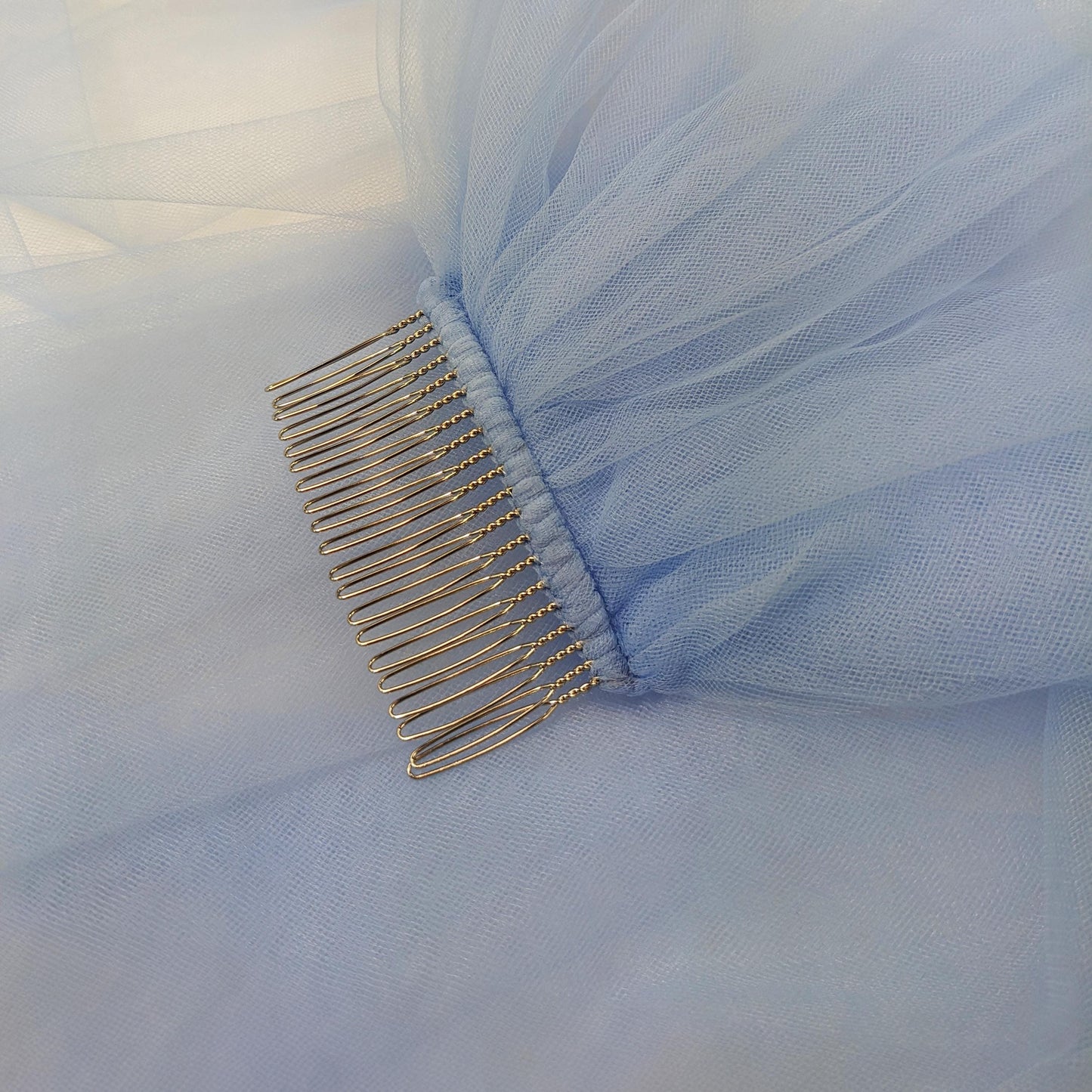 Close-up of a blue veil with gold hair comb 